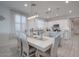 Bright dining area with an elegant chandelier, adjacent to a modern kitchen at 40520 W Haley Dr, Maricopa, AZ 85138