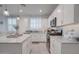 Bright kitchen features white cabinets, granite countertops, and stainless steel appliances at 40520 W Haley Dr, Maricopa, AZ 85138