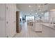 Bright kitchen with white cabinetry, stainless steel appliances, and an open view to the dining and living areas at 40520 W Haley Dr, Maricopa, AZ 85138