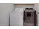 Modern laundry room with a front-load washer and dryer at 40520 W Haley Dr, Maricopa, AZ 85138