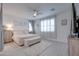 Serene main bedroom with neutral tones, a ceiling fan, and soft natural light streaming through the windows at 40520 W Haley Dr, Maricopa, AZ 85138