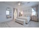 Bright and airy main bedroom with a large bed, decorative mirror, and ample natural light at 40520 W Haley Dr, Maricopa, AZ 85138