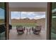 Inviting covered patio with seating overlooking a small backyard with artificial grass at 40520 W Haley Dr, Maricopa, AZ 85138