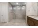 Primary bath features a luxurious glass shower with built in bench, vanity, and white door at 42850 W Palo Abeto Dr, Maricopa, AZ 85138