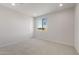 Bright bedroom with neutral carpet, white walls, and a window offering natural light and views at 42850 W Palo Abeto Dr, Maricopa, AZ 85138