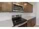 Close-up of the stove and microwave area with modern stainless steel appliances at 42850 W Palo Abeto Dr, Maricopa, AZ 85138