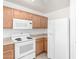 This kitchen includes a white fridge, white stove, microwave, and wood cabinets at 44792 W Paitilla Ln, Maricopa, AZ 85139