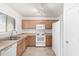 Bright kitchen with stainless steel sink, white appliances, and lots of natural light at 44792 W Paitilla Ln, Maricopa, AZ 85139