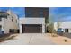 Striking modern home with a dark garage door, complemented by desert landscaping and unique architectural details at 4514 N 8Th Pl, Phoenix, AZ 85014