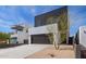 Contemporary home with a dark garage door and desert landscaping, framed by a clear blue sky at 4514 N 8Th Pl, Phoenix, AZ 85014