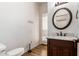 Well-appointed powder room features a dark wood vanity with a decorative mirror at 5323 W Rose Garden Ln, Glendale, AZ 85308