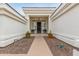 Elegant home entrance featuring potted plants, desert landscaping, and a custom wood door with side windows at 5323 W Rose Garden Ln, Glendale, AZ 85308