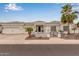 Stunning white home featuring a well-kept landscape, tile roof, three car garage, and a decorative front gate at 5323 W Rose Garden Ln, Glendale, AZ 85308