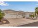 Lovely white home featuring a three-car garage, desert landscaping, and spacious driveway at 5323 W Rose Garden Ln, Glendale, AZ 85308