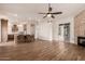 Open concept living room boasts wood floors, breakfast bar, fireplace, and ceiling fan at 5323 W Rose Garden Ln, Glendale, AZ 85308