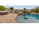 Beautiful pool with rock waterfall feature and serene views of the community lake at 5323 W Rose Garden Ln, Glendale, AZ 85308
