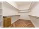 Walk-in closet with wood floors, shelving, and ample storage at 5323 W Rose Garden Ln, Glendale, AZ 85308
