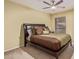 Comfortable bedroom features a ceiling fan, plush bedding, and natural light from the window at 6138 E Nance St, Mesa, AZ 85215