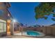 Well-lit backyard features a pool with fence, covered patio, and lush landscaping at 7415 W Via De Luna Dr, Glendale, AZ 85310