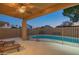 Outdoor patio with fan overlooks the fenced pool and yard at 7415 W Via De Luna Dr, Glendale, AZ 85310