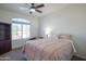 Inviting bedroom with a ceiling fan, arched window, and plush carpeting at 7415 W Via De Luna Dr, Glendale, AZ 85310
