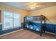 Cozy bedroom with a baseball themed bunk bed, neutral carpet, and blue and yellow paint at 7415 W Via De Luna Dr, Glendale, AZ 85310
