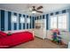 Fun bedroom with blue striped walls, a red bed, white trim, and ample natural light at 7415 W Via De Luna Dr, Glendale, AZ 85310
