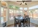 Bright dining area featuring a dark wood table, tile floors, a ceiling fan, and views of the backyard play area at 7415 W Via De Luna Dr, Glendale, AZ 85310