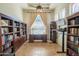 Office area featuring a ceiling fan, a window with curtains, a wooden desk and built-in bookshelves at 7415 W Via De Luna Dr, Glendale, AZ 85310