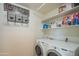 Functional laundry room with a washer and dryer, shelving for storage, and clean white walls at 7415 W Via De Luna Dr, Glendale, AZ 85310