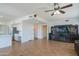Open floor plan living room featuring a ceiling fan, and entertainment center with a large TV at 7415 W Via De Luna Dr, Glendale, AZ 85310