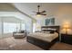 Relaxing main bedroom with ceiling fan, chaise lounge, and large windows at 7415 W Via De Luna Dr, Glendale, AZ 85310