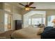 Spacious main bedroom featuring a cozy seating area, a ceiling fan, and an ensuite bathroom at 7415 W Via De Luna Dr, Glendale, AZ 85310