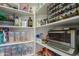 Well-stocked pantry featuring white shelving and a variety of spices, oils, and storage containers at 7415 W Via De Luna Dr, Glendale, AZ 85310