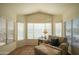 Comfortable sitting area in main bedroom with a plush chaise lounge, a side table and natural light at 7415 W Via De Luna Dr, Glendale, AZ 85310