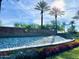 Sun City Anthem entrance with water feature, lush flowers, palm trees, and beautiful blue sky at 8071 W Valor Way, Florence, AZ 85132