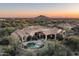 Aerial view of the backyard and pool showing the home's location amongst the desert landscape at 8496 E Homestead Cir, Scottsdale, AZ 85266