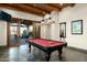 Game room with a pool table, wood ceiling beams, and sliding glass doors leading to the patio at 8496 E Homestead Cir, Scottsdale, AZ 85266