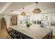 Bright kitchen featuring a large marble island, white cabinets, and modern pendant lighting at 8740 E Mulberry St, Scottsdale, AZ 85251
