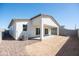 Backyard featuring a covered patio, stucco exterior, and gravel landscaping at 909 E Desert Ln, Phoenix, AZ 85042