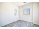 Bright bedroom with wood-look floors and two windows letting in natural light at 909 E Desert Ln, Phoenix, AZ 85042