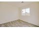 A bright bedroom features wood-look flooring and a window with a view at 909 E Desert Ln, Phoenix, AZ 85042