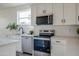 The white kitchen features stainless appliances, quartz counters, and a modern subway tile backsplash at 909 E Desert Ln, Phoenix, AZ 85042