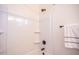 A pristine white shower features a built-in seat and sleek black hardware at 909 E Desert Ln, Phoenix, AZ 85042