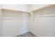 Empty walk-in closet featuring custom shelving and wood-look flooring at 909 E Desert Ln, Phoenix, AZ 85042