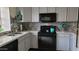 Renovated kitchen with stainless steel sink, black appliances, and gray mosaic tile backsplash at 921 W University Dr # 1101, Mesa, AZ 85201