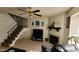 Open concept living area with tile floors, staircase, fireplace, and comfortable seating at 921 W University Dr # 1101, Mesa, AZ 85201