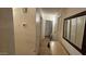 Hallway featuring neutral walls, tile floors, doors, and a mirror adding depth at 1001 N Nielson St, Gilbert, AZ 85234