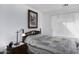 Bright bedroom with a patterned quilt, a bedside table, and a window with sheer curtains at 11408 E Natal Ave, Mesa, AZ 85209
