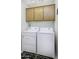 Efficient laundry room with matching washer and dryer and overhead cabinets for storage at 11408 E Natal Ave, Mesa, AZ 85209